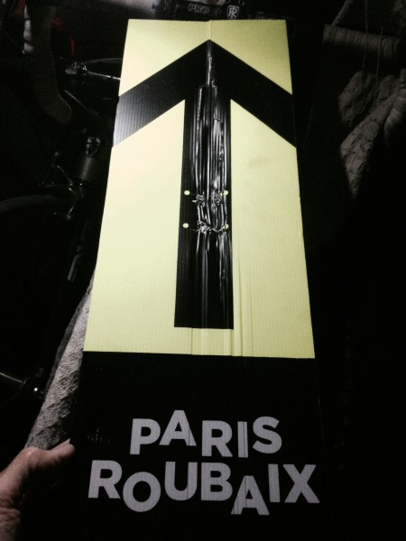 Trudi brought me back a Paris-Roubaix directional sign from the race, for the garage.