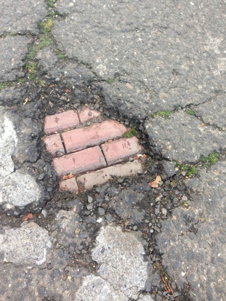 I took a photo of this pothole in the asphalt.  It's too bad they covered up the bricks.