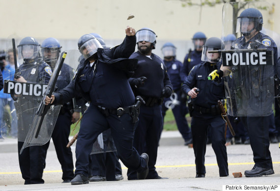 A police officer throws an object at protestors.  (AP Photo/Patrick Semansky)
