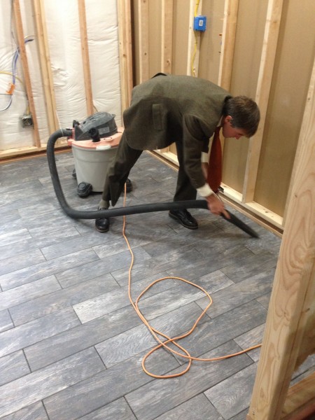 Vincent cleaning grouts lines in a suit.