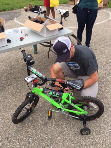 Dan Hughes, owner of Sunflower Bike shop, mounting some lights on one of the kid's bikes.